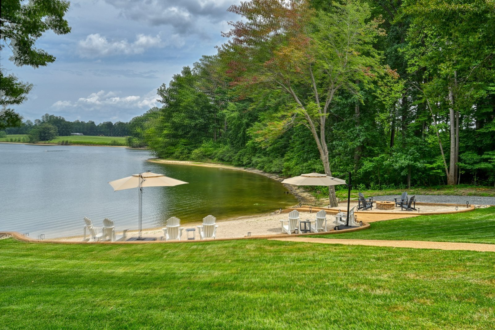 Private sand beach with umbrellas and lounge chairs on the lake