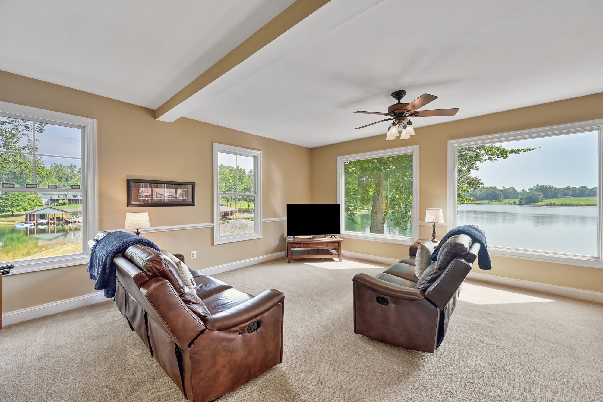 Family room with recliner sofas, TV and lake views