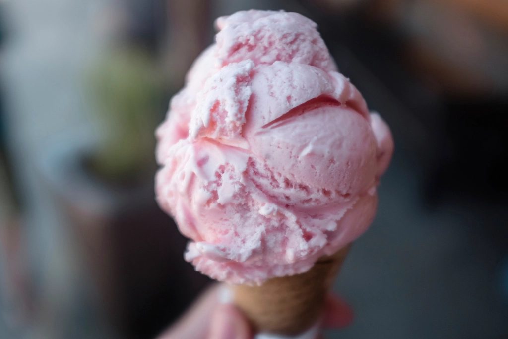 Scoop of pink strawberry ice cream on a cone