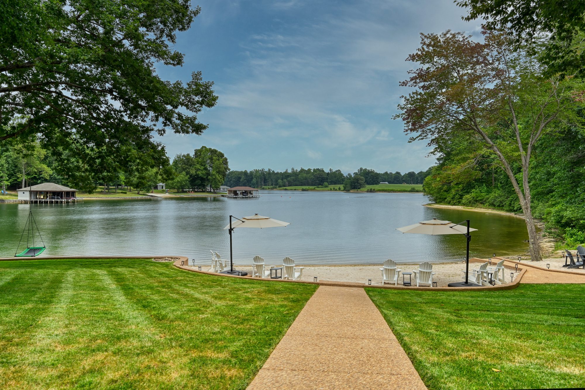 Lawn path to the private sand beach with Adirondack chairs and umbrellas
