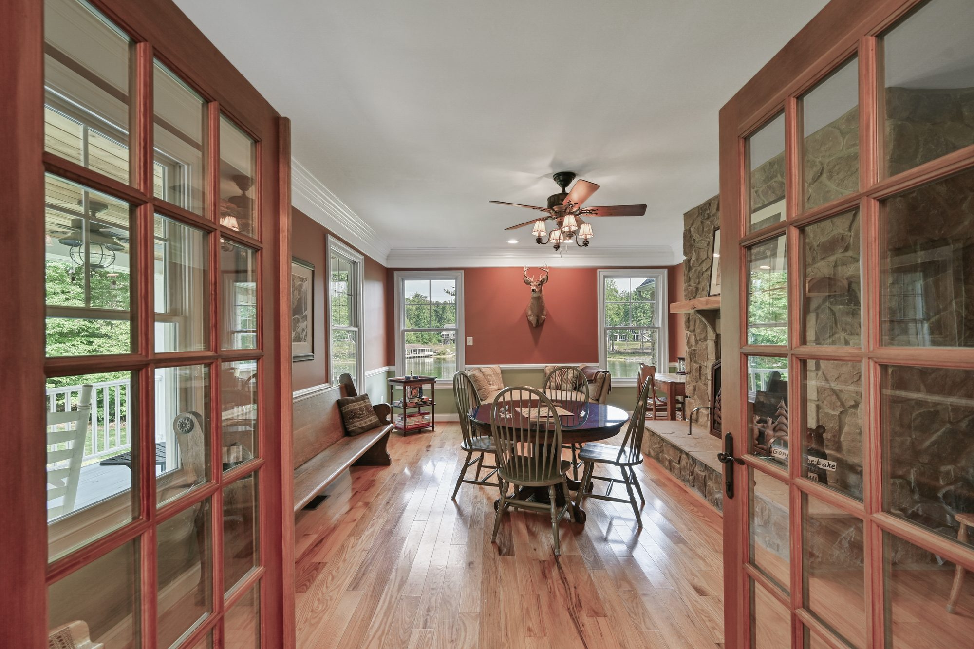 French doors into the fireplace game room with lake-view windows